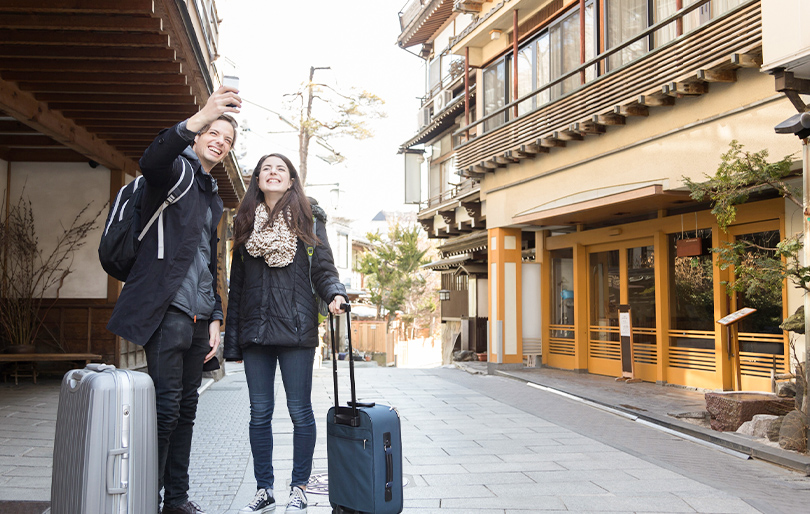 日本の街並みで観光を楽しむ外国人旅行者